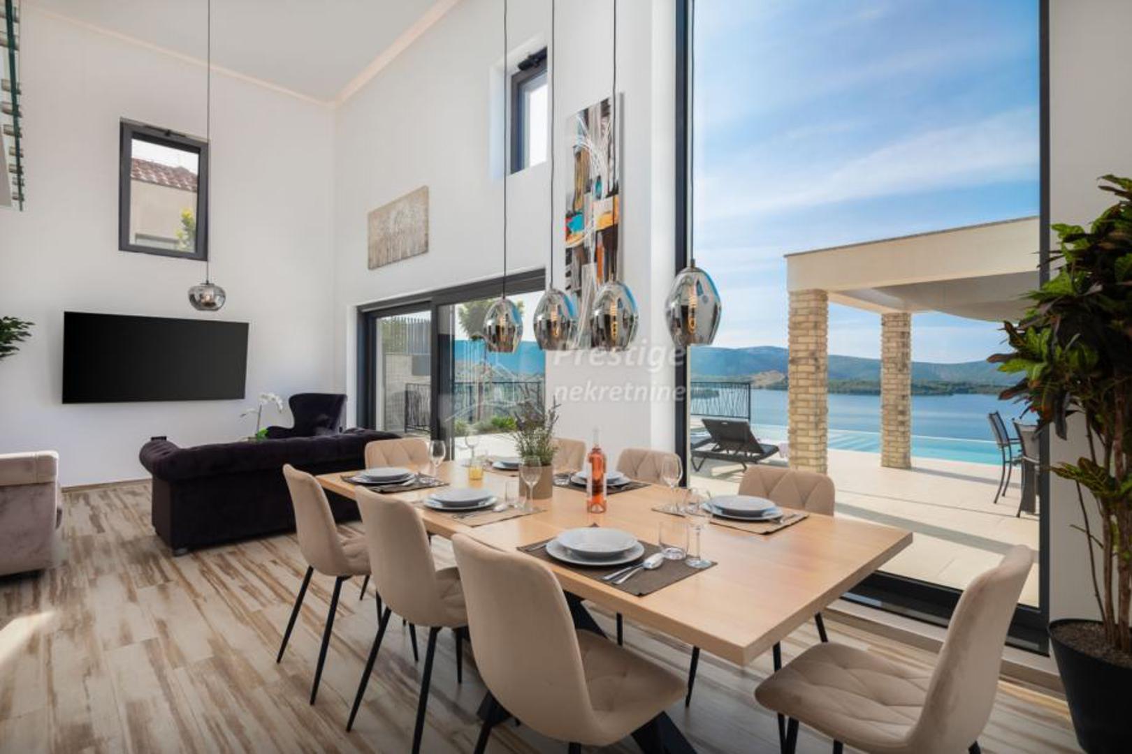 Glavna kuća nudi prostrane dnevne prostore, modernu kuhinju s blagovaonicom, boravak, pomoćni boravak te četiri spavaće sobe s vlastitim kupaonicama i otvorenim pogledom na more. 