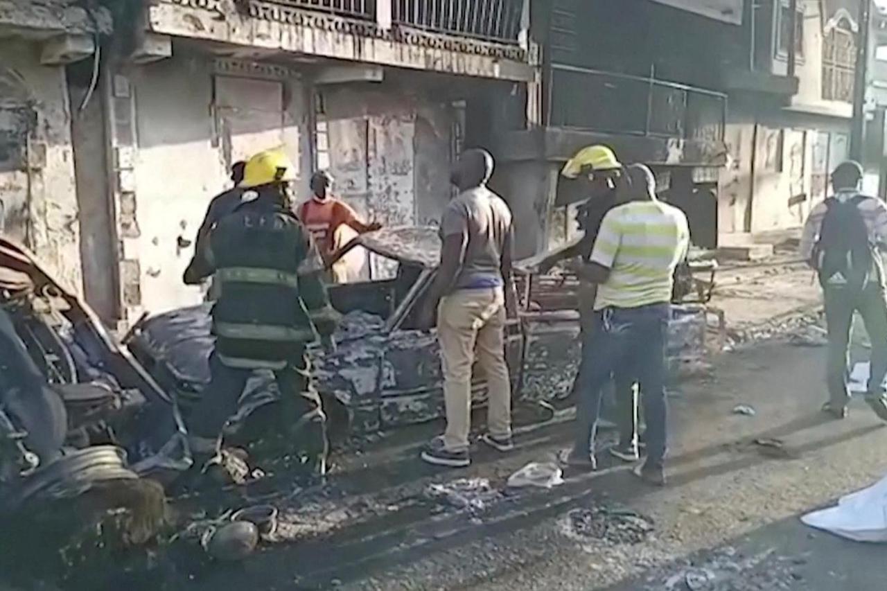 People stand at the site of an explosion in Cap-Haitien