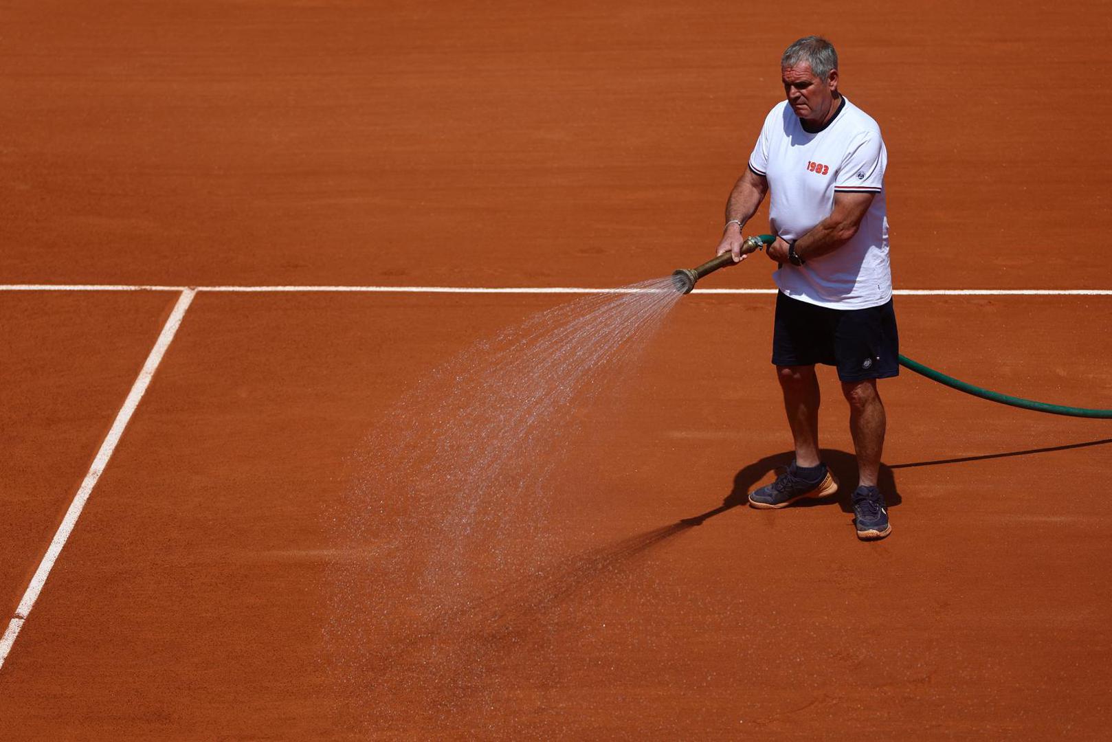Tennis - French Open - Roland Garros, Paris, France - May 28, 2023 A member of the ground staff waters the clay during the first round match between Greece's Stefanos Tsitsipas and Czech Republic's Jiri Vesely REUTERS/Kai Pfaffenbach Photo: Kai Pfaffenbach/REUTERS
