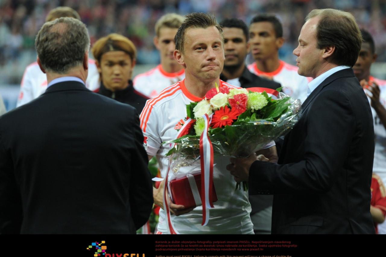 \'Bayern Munich\'s Ivica Olic (C) is seen off by the chairman of the board of Bundesliga soccer club Bayern Munich, Karl-Heinz Rummenigge (L) and the club\'s sports director Christian Nerlingern prior