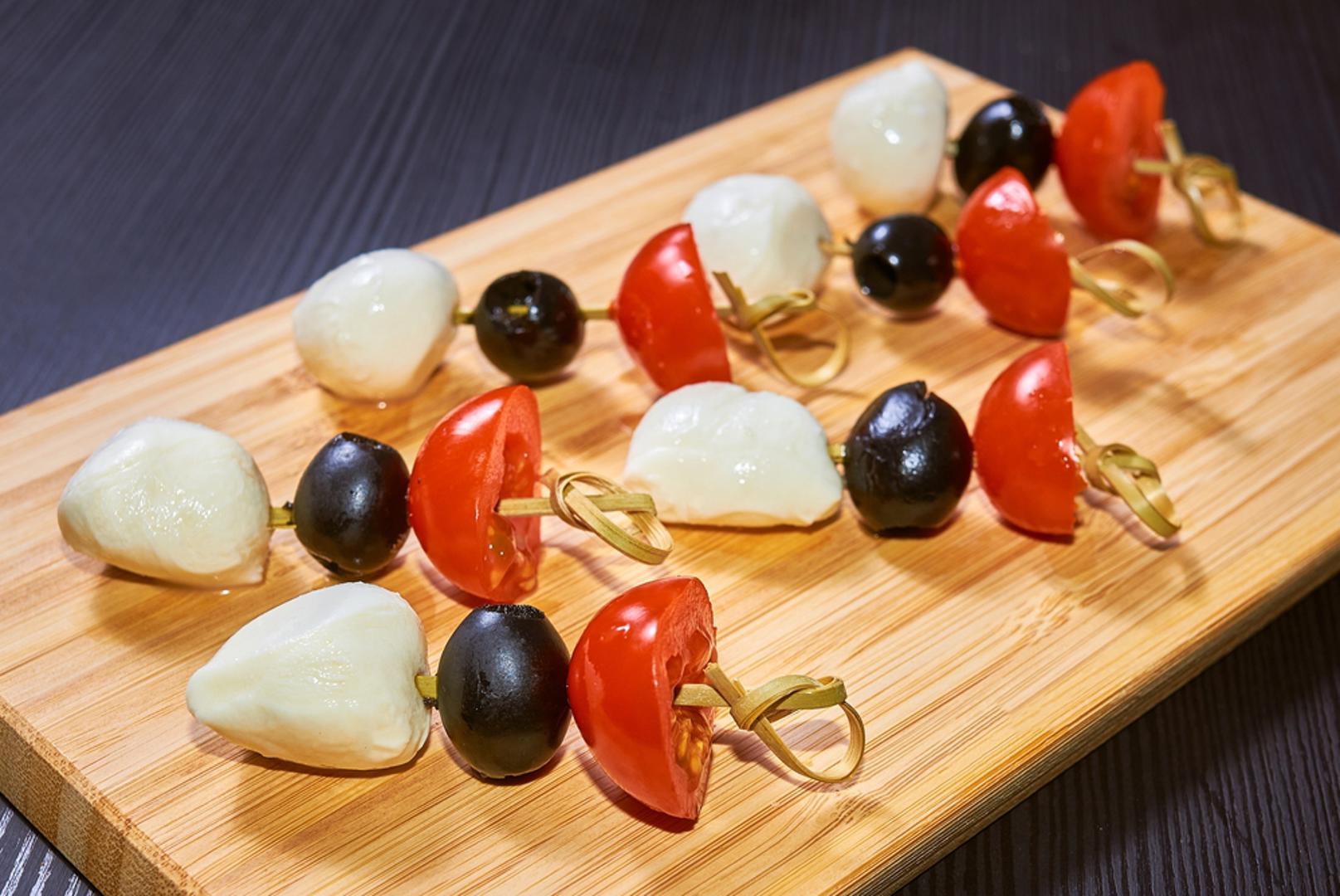 Mini ražnjići od mozzarelle, rajčice i maslina: Za lagan i dekorativan navijački zalogaj odlični su mali ražnjići od cherry rajčica, kuglica mozzarelle i maslina. Sve se može složiti na čačkalice i začiniti s malo maslinova ulja, bosiljka, soli i papra. Ovi zalogaji brzo se pripremaju, lako se jedu i unose mediteranski štih na navijački stol.