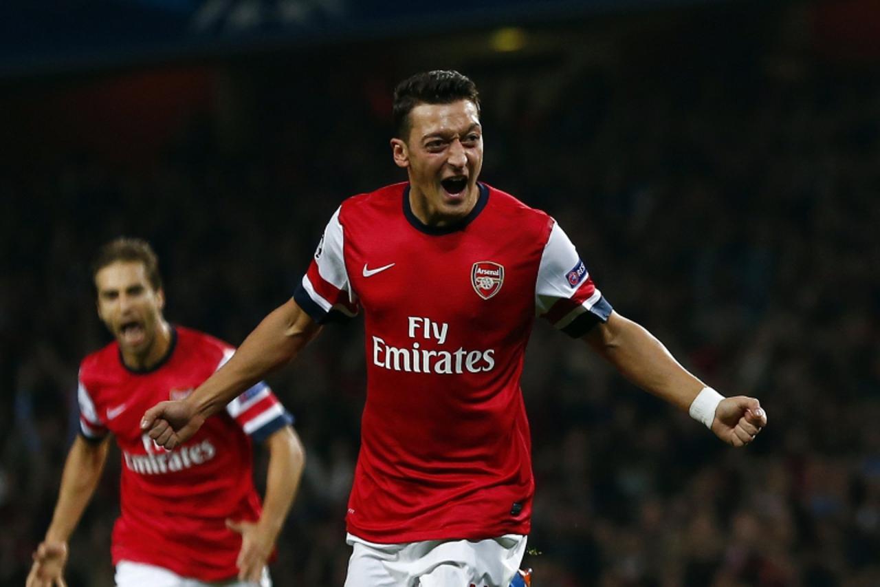 'Arsenal\'s Mesut Ozil celebrates after scoring a goal against Napoli during their Champions League soccer match at the Emirates stadium in London October 1, 2013. REUTERS/Eddie Keogh   (BRITAIN - Tag