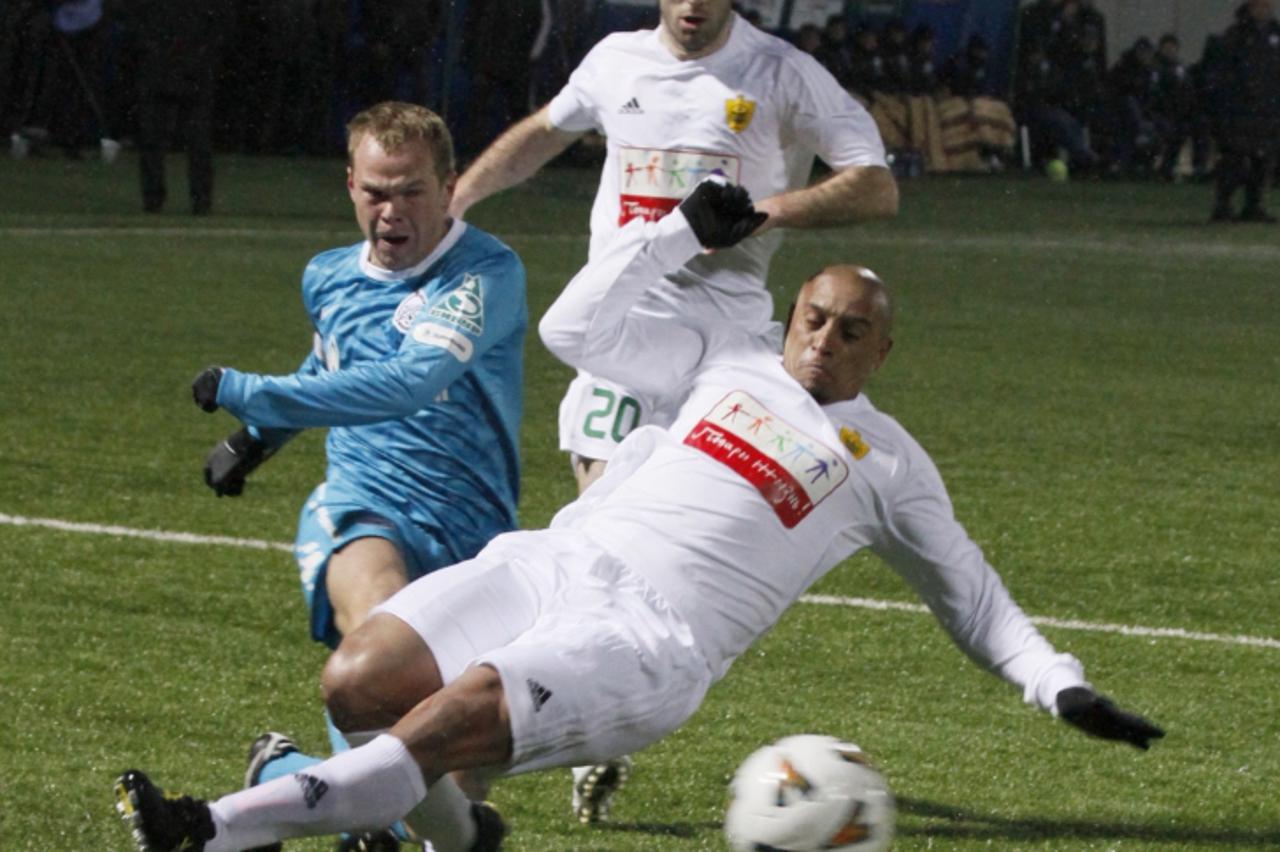 'Former Brazilian fullback Roberto Carlos (R) of Anzhi Makhachkala challenges Alexander Anyukov (L) of Zenit St.Petersburg in their Russian cup match in the Chechen capital Grozny March 1, 2011.  REUT