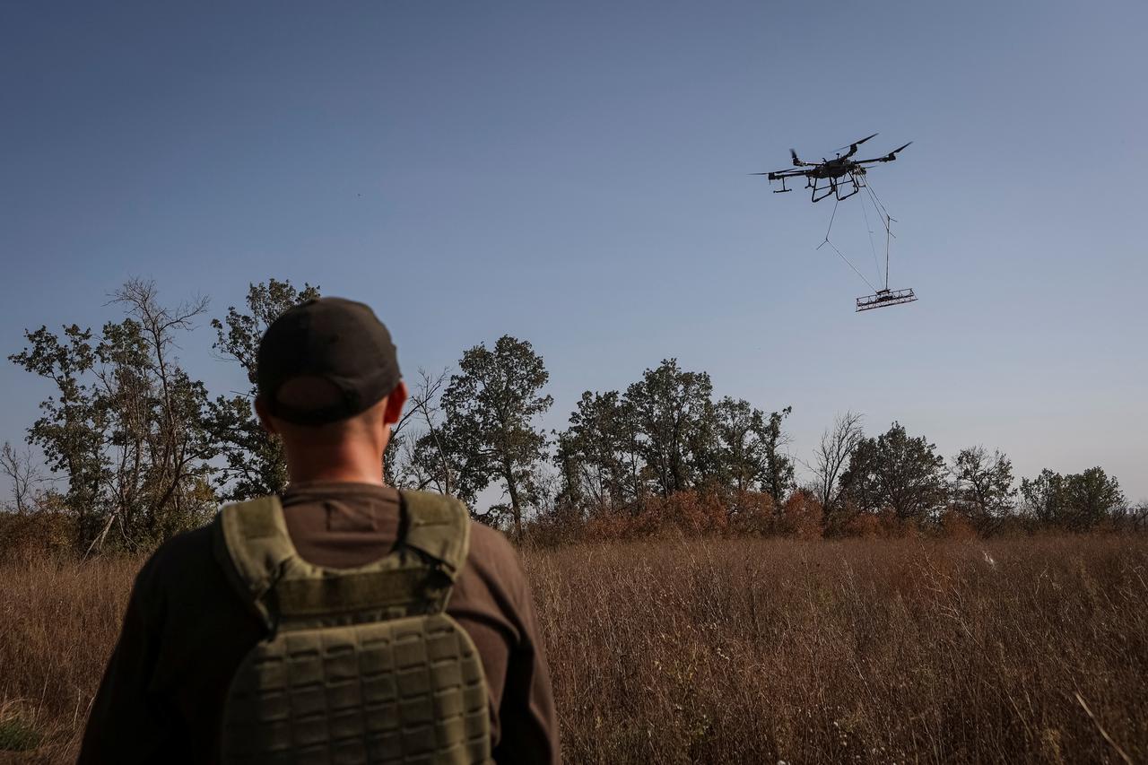 A member of the volunteer organization 'Postup' operates a drone during demining near the town of Derhachi