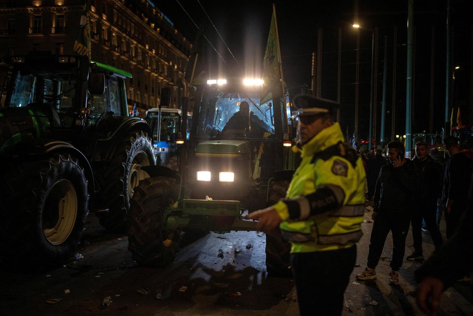 A police officer gives directions to a farmer driving his tractor as Greek farmers protest over rising energy costs and competition from imports, in front of the parliament building in Athens, Greece, February 20, 2024. REUTERS/Alkis Konstantinidis Photo: Alkis Konstantinidis/REUTERS