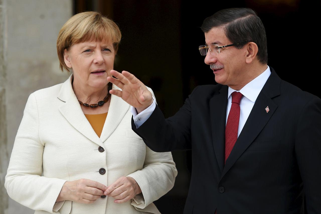 Turkish Prime Minister Ahmet Davutoglu (R) chats with German Chancellor Angela Merkel before their meeting in Istanbul, Turkey, October 18, 2015. Merkel travelled to Istanbul on Sunday desperate to secure Turkey's help in stemming the flow of migrants fro