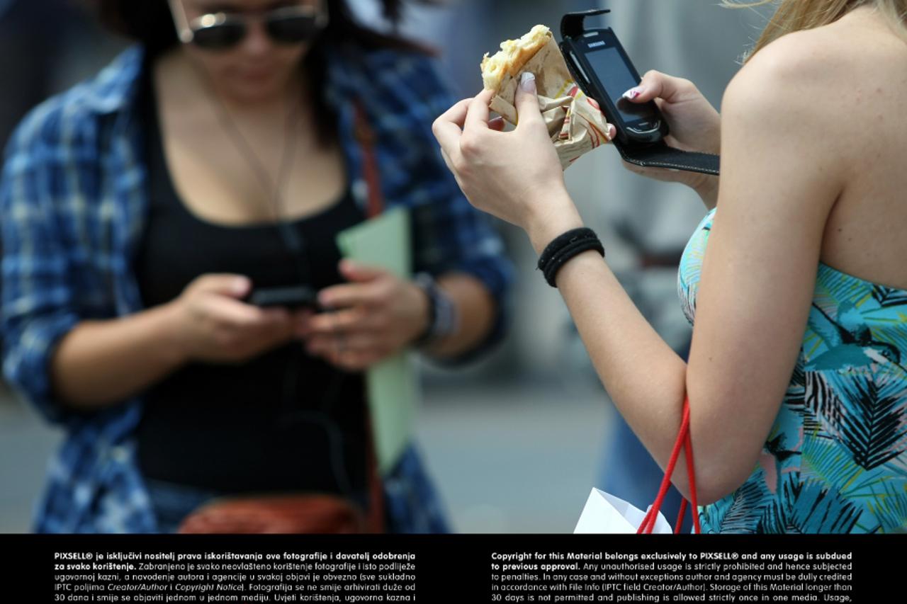 sendvič, junk food, nezdrava prehrana, hrana, žena, djevojka, hodanje, mobitel moderan život,  posao (1)