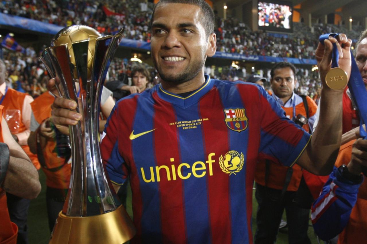 \'Barcelona\'s Dani Alves holds the trophy after defeating Estudiantes\' in their FIFA Club World Cup final soccer match at Zayed Sports City stadium in Abu Dhabi December 19, 2009.  REUTERS/Fadi Al-A