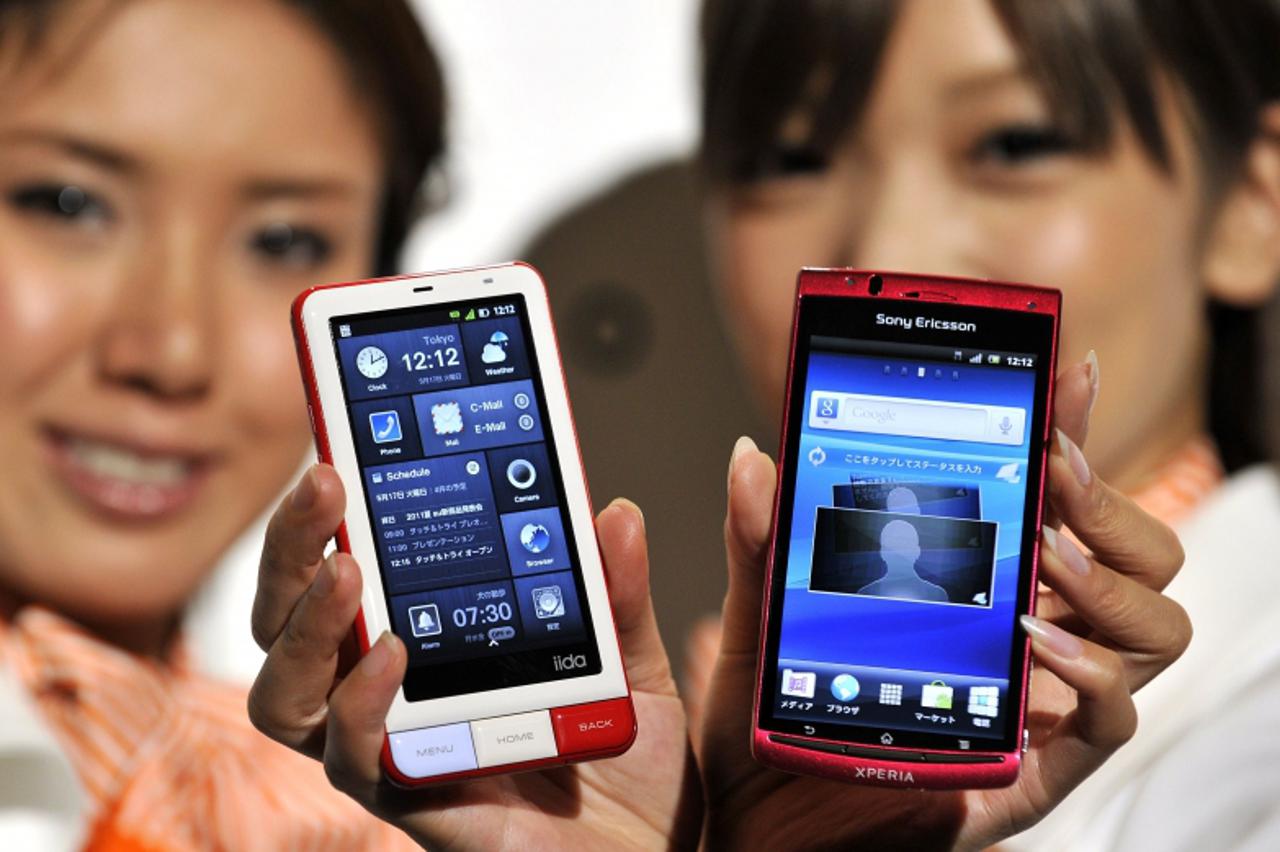 'Models display KDDI\'s new smart phones, Sony Ericsson\'s Xperia (R) and Infobar A01, made by Sharp with Android 2.3 OS, at a press preview in Tokyo on May 17, 2011.  KDDI announced six new models of