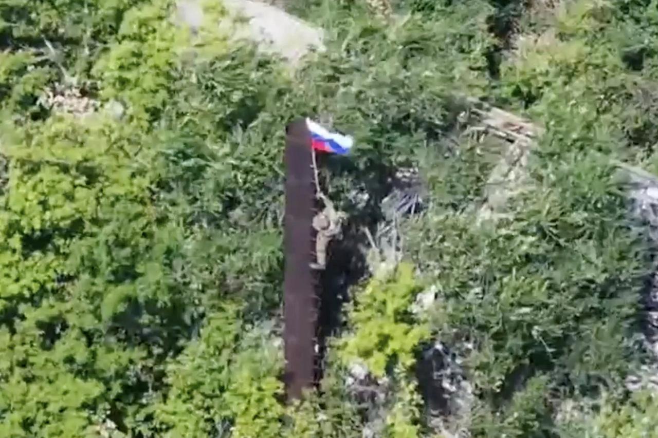 A still image from video released by Russian Defence Ministry shows what it said to be Russian soldier raising flag in Yablunivka in Donetsk region