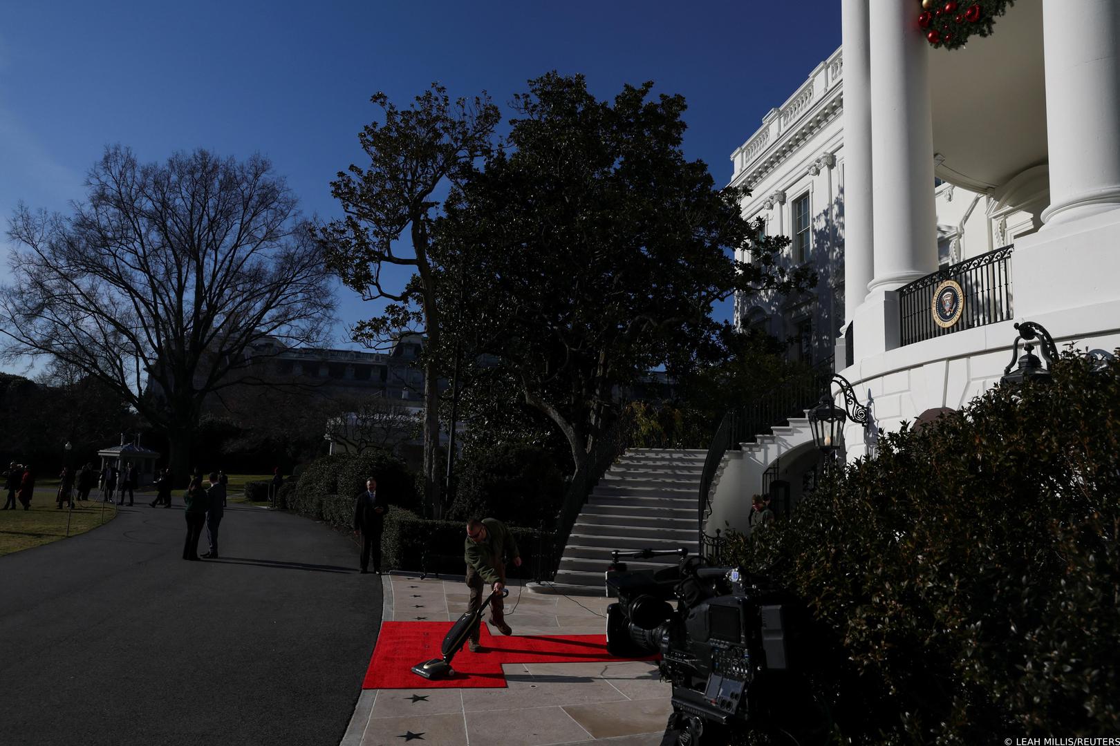 A worker vacuums a red carpet prior to U.S. President Joe Biden welcoming Ukraine's President Volodymyr Zelenskiy on the South Lawn of the White House in Washington, U.S., December 21, 2022. REUTERS/Leah Millis Photo: LEAH MILLIS/REUTERS