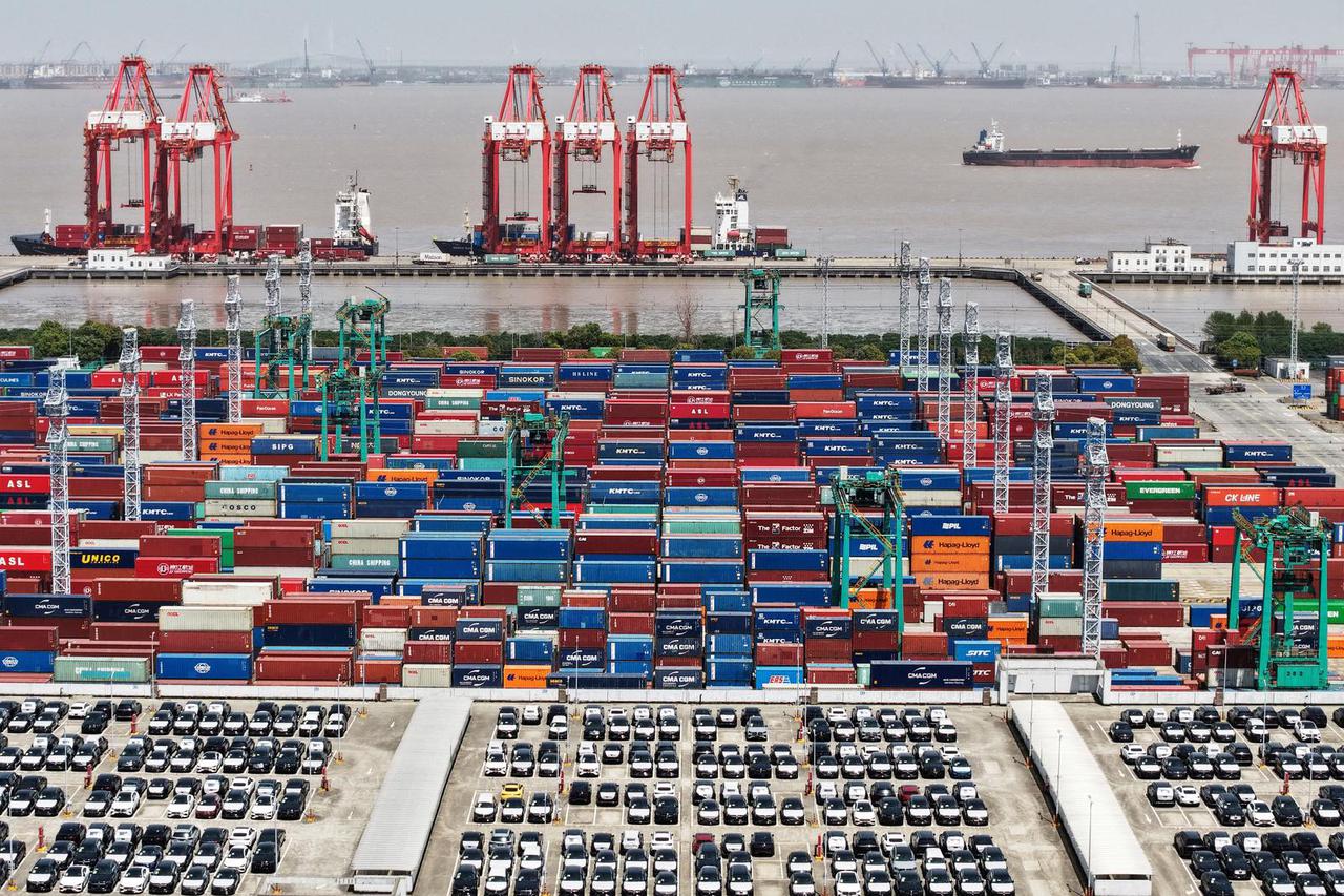 FILE PHOTO: Drone view shows electric vehicles (EV) for export and containers sitting at a port in Shanghai