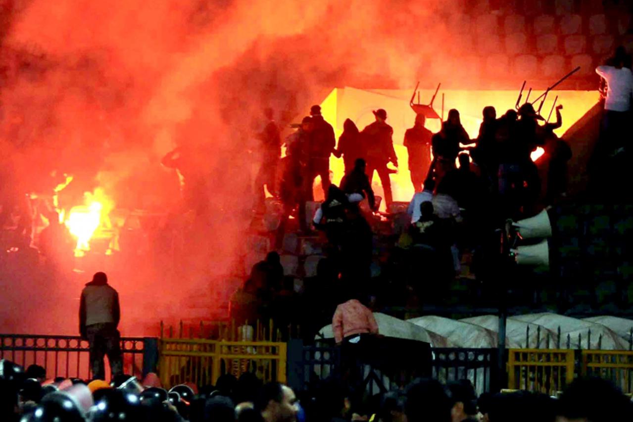 'epa03088471 Egyptian soccer fans seen during clashes as security forces stand on the pitch at the stadium of Port Said, Egypt, 01 February 2012. According to local media reports, at least seventy peo