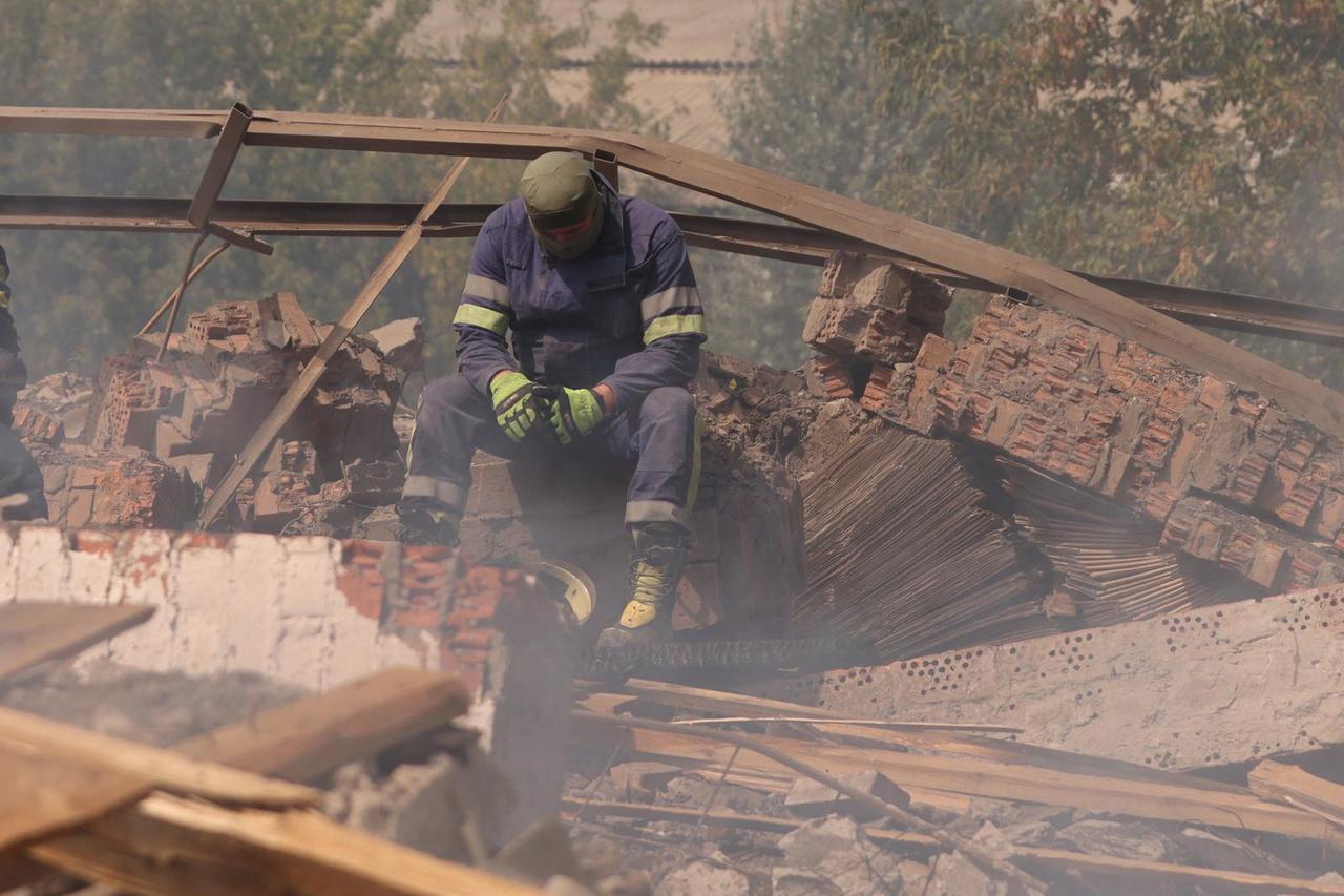A Ukrainian firefighter takes a rest in a factory destroyed by a Russian strike in the city of Slovyansk
