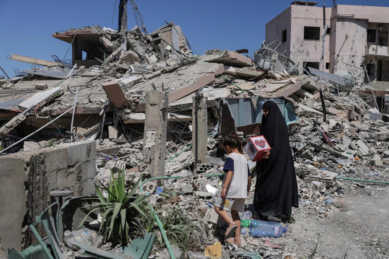 A woman returning to her village after displacement by the war holds a box salvaged from her neighbour’s house, in Qlaileh, Tyre district
