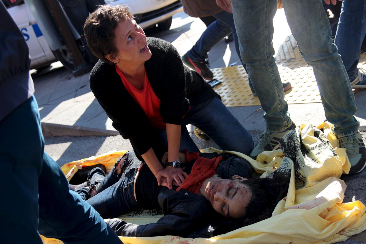 ATTENTION EDITORS - VISUAL COVERAGE OF SCENES OF INJURY OR DEATHA woman helps an injured woman after an explosion during a peace march in Ankara, Turkey, October 10, 2015. At least one explosion shook a road junction in the centre of the Turkish capital A