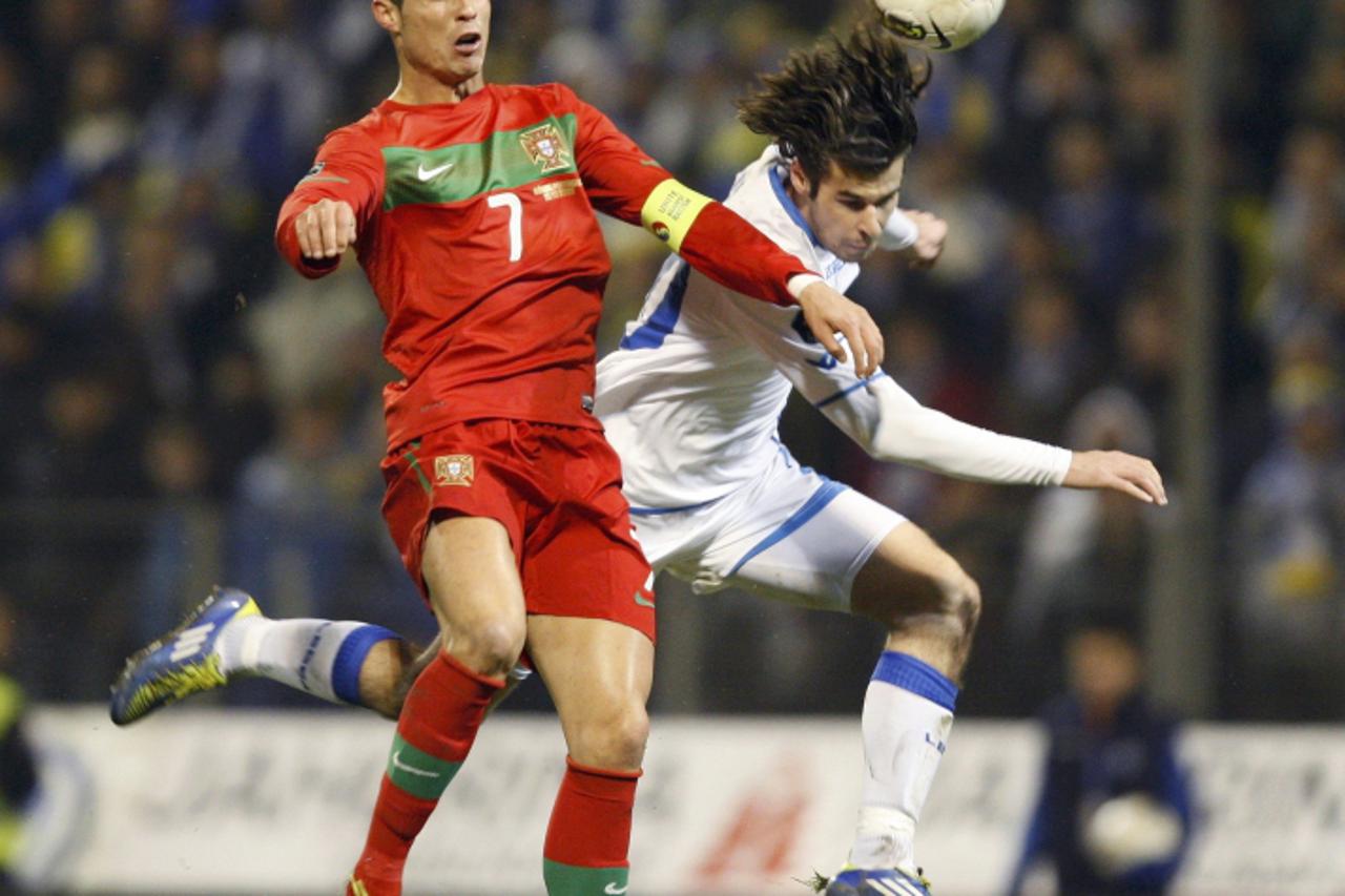 'Cristiano Ronaldo (L) of Portugal is challenged by Adnan Zahirovic of Bosnia during their Euro 2012 play-off first leg qualifying soccer match in the town of Zenica November 11, 2011.       REUTERS/N