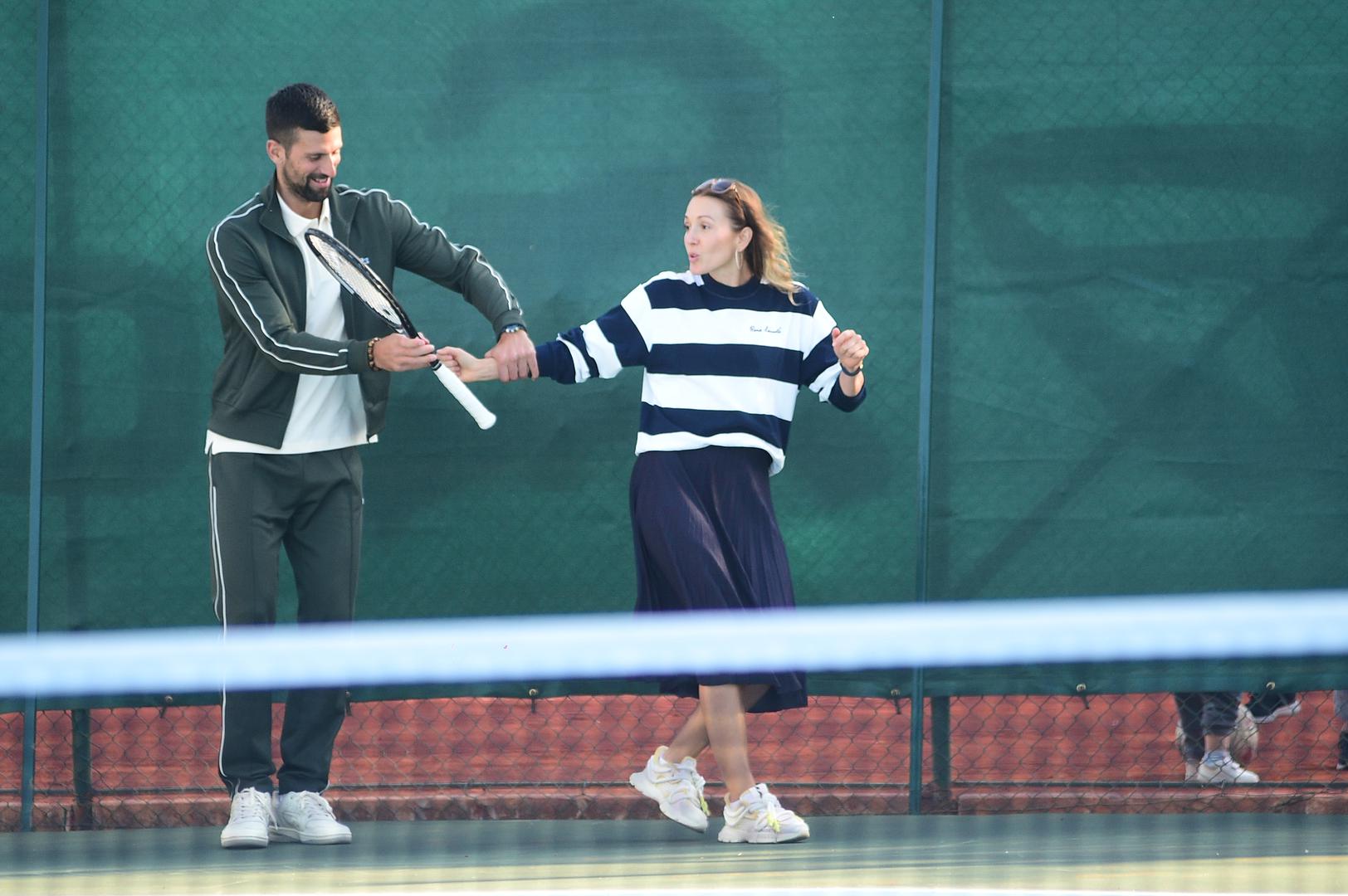 Dobro raspoloženi Nole zaigrao je tenis s najmlađima, a u jednom trenutku čak je simpatično "natjerao" suprugu Jelenu da i sama uhvati reket. Ovaj prizor para, opuštenog i nasmijanog, rijetkost je koju javnost cijeni.