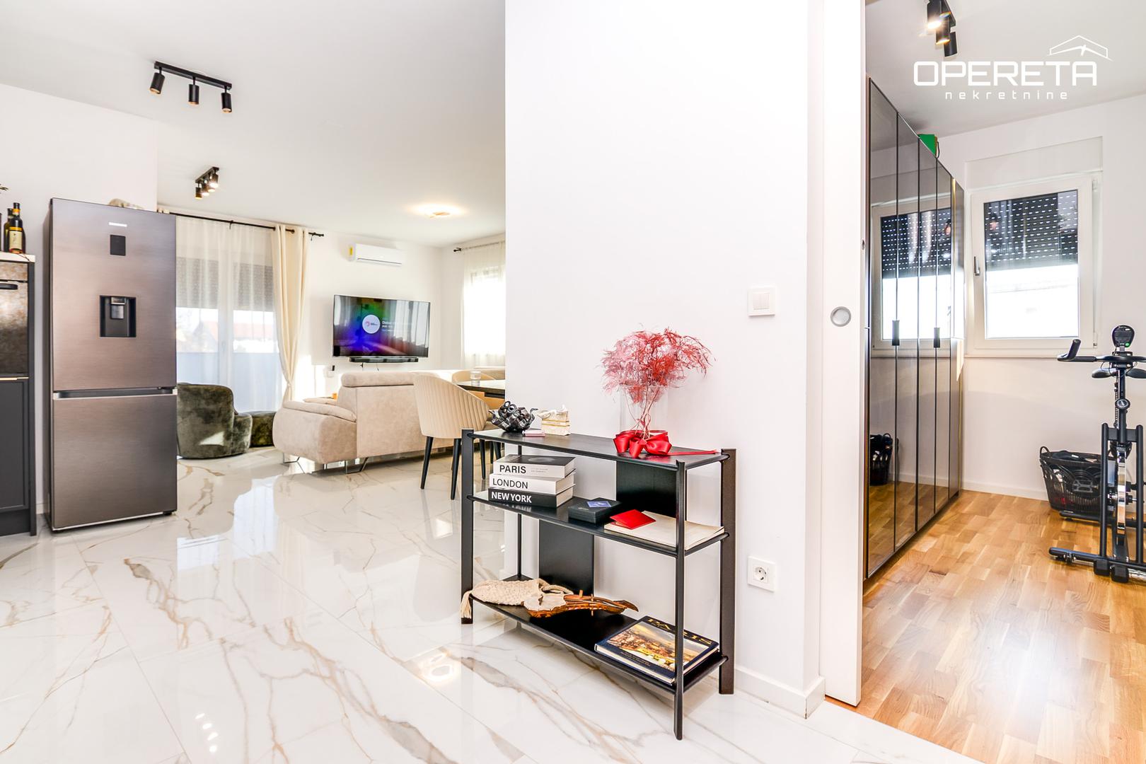 Stan se sastoji od prostranog dnevnog boravka otvorenog koncepta koji je povezanim s kuhinjom i blagovaonicom, stvarajući funkcionalan prostor za obiteljske trenutke i druženja.