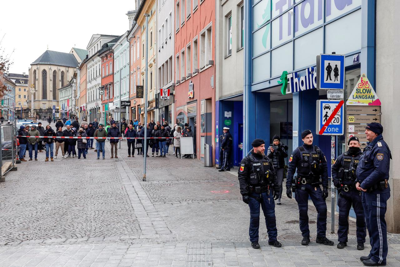 Police officers stand guard at the scene where a 14-year-old boy was killed and several others were wounded in a stabbing attack, in the town of Villach