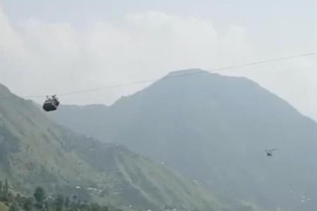 A view shows a helicopter carrying rescue operation next to the cable car with students stranded mid-air in Battagram