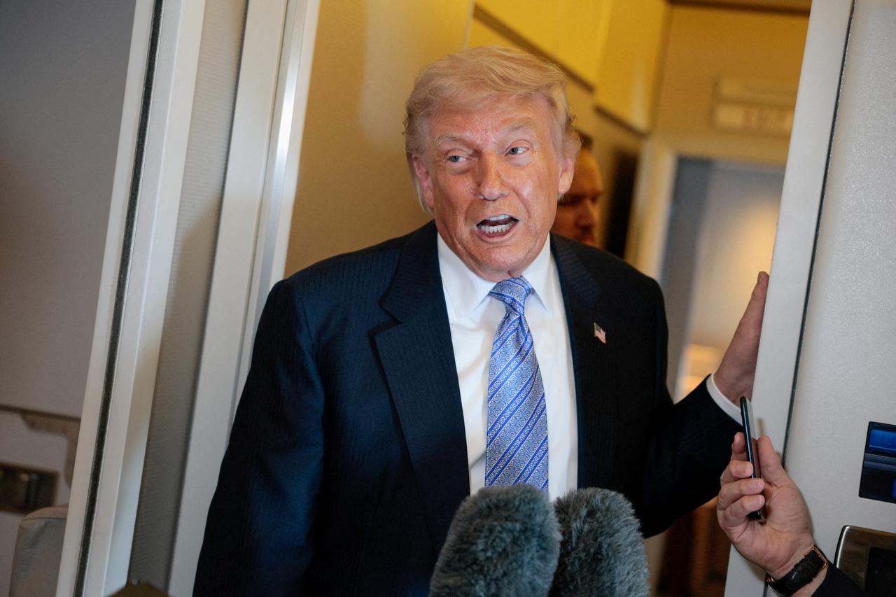 FILE PHOTO: U.S. President Donald Trump speaks to members of the media on board Air Force One, following his visit to China