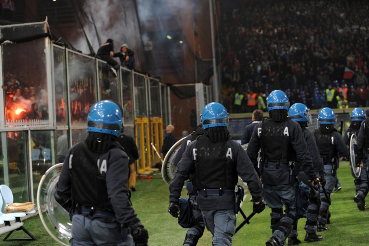 'Riot policemen run on the pitch before the European 2012 qualifyng football match between Italy and Serbia is suspended due to fan violence at Luigi Ferraris stadium in Genoa on October 12, 2010. Fou