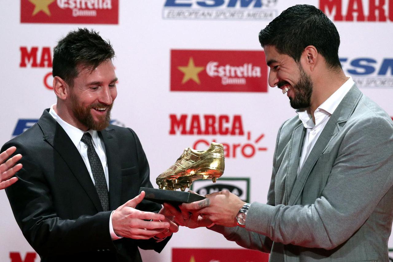 FILE PHOTO: Barcelona's Lionel Messi receives his fourth Golden Boot trophy from Luis Suarez during a ceremony in Barcelona