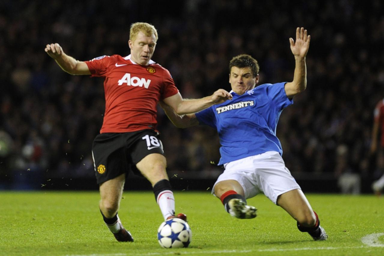 'Manchester United\'s Paul Scholes (L) is challenged by Rangers\' Lee McCulloch during their Champions League soccer match at Ibrox Stadium, Glasgow, Scotland, November 24, 2010. REUTERS/Russell Cheyn