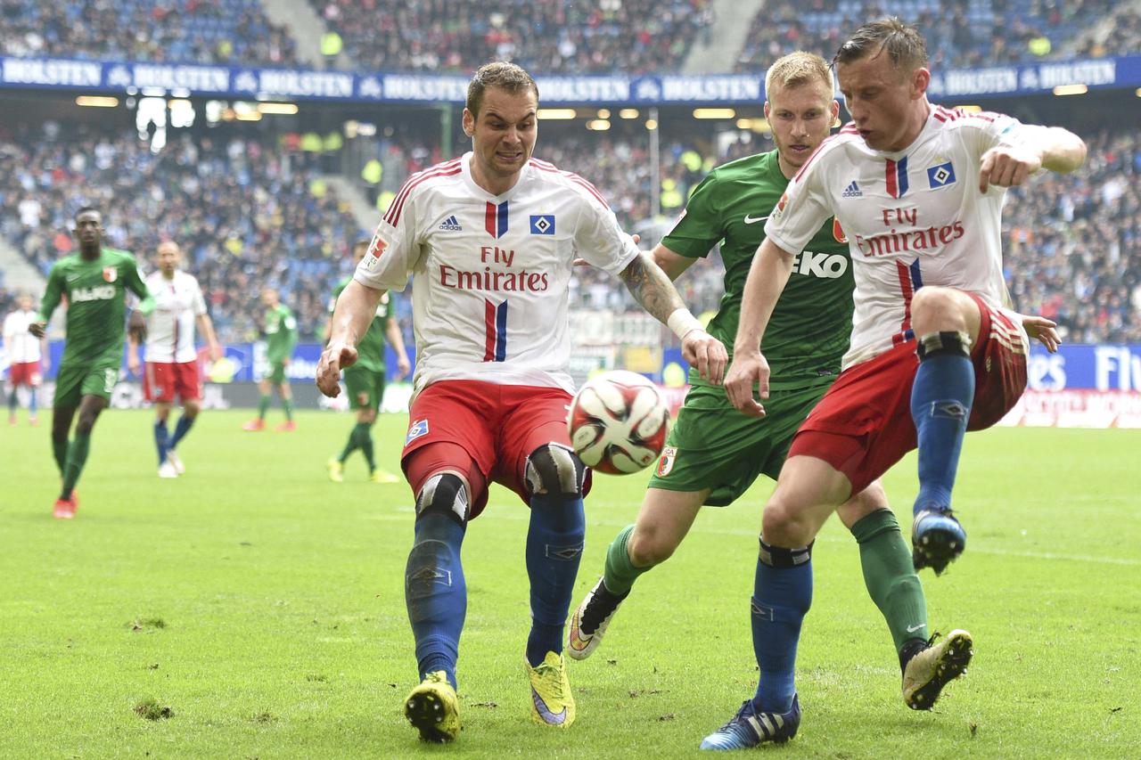 Hamburg SV's Pierre-Michel Lasogga (L) and Ivica Olic (R) fight for the ball with FC Augsburg's Ragnar Klavan during their German Bundesliga first division soccer match in Hamburg , April 25, 2015. REUTERS/Fabian Bimmer. DFL RULES TO LIMIT THE ONLINE USAG