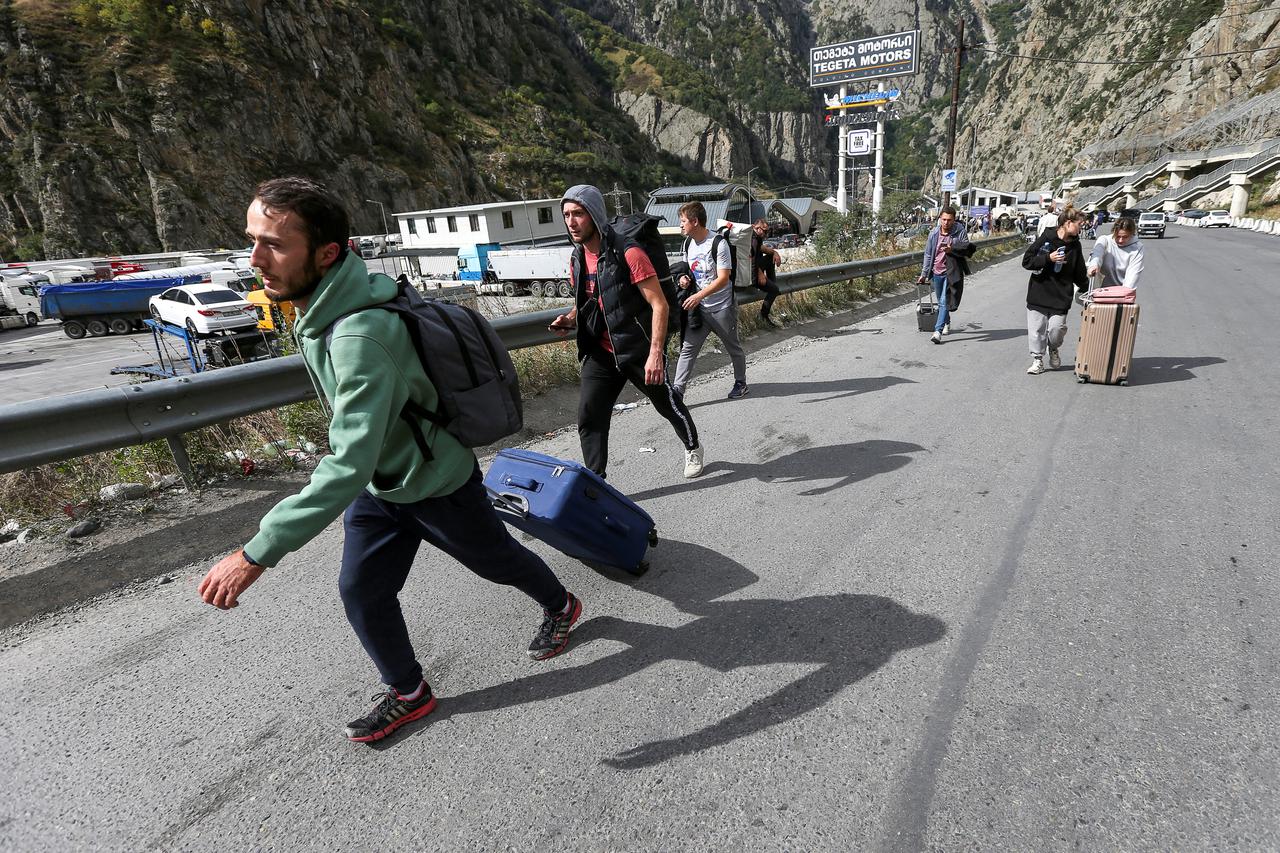 People cross border at Zemo Larsi checkpoint while leaving Russia
