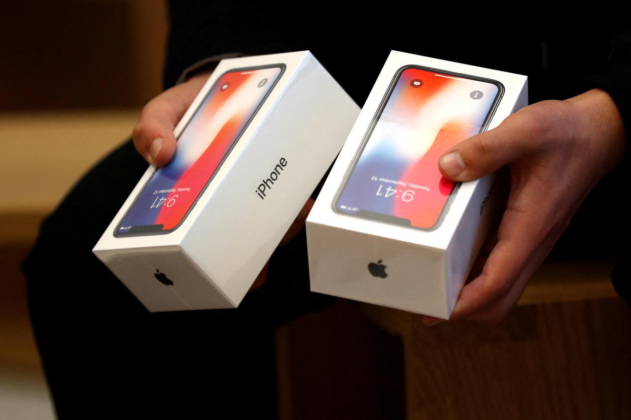 FILE PHOTO: A man holds two boxes for the Apple’s new iPhone X which went on sale today, at the Apple Store in Regents Street in London