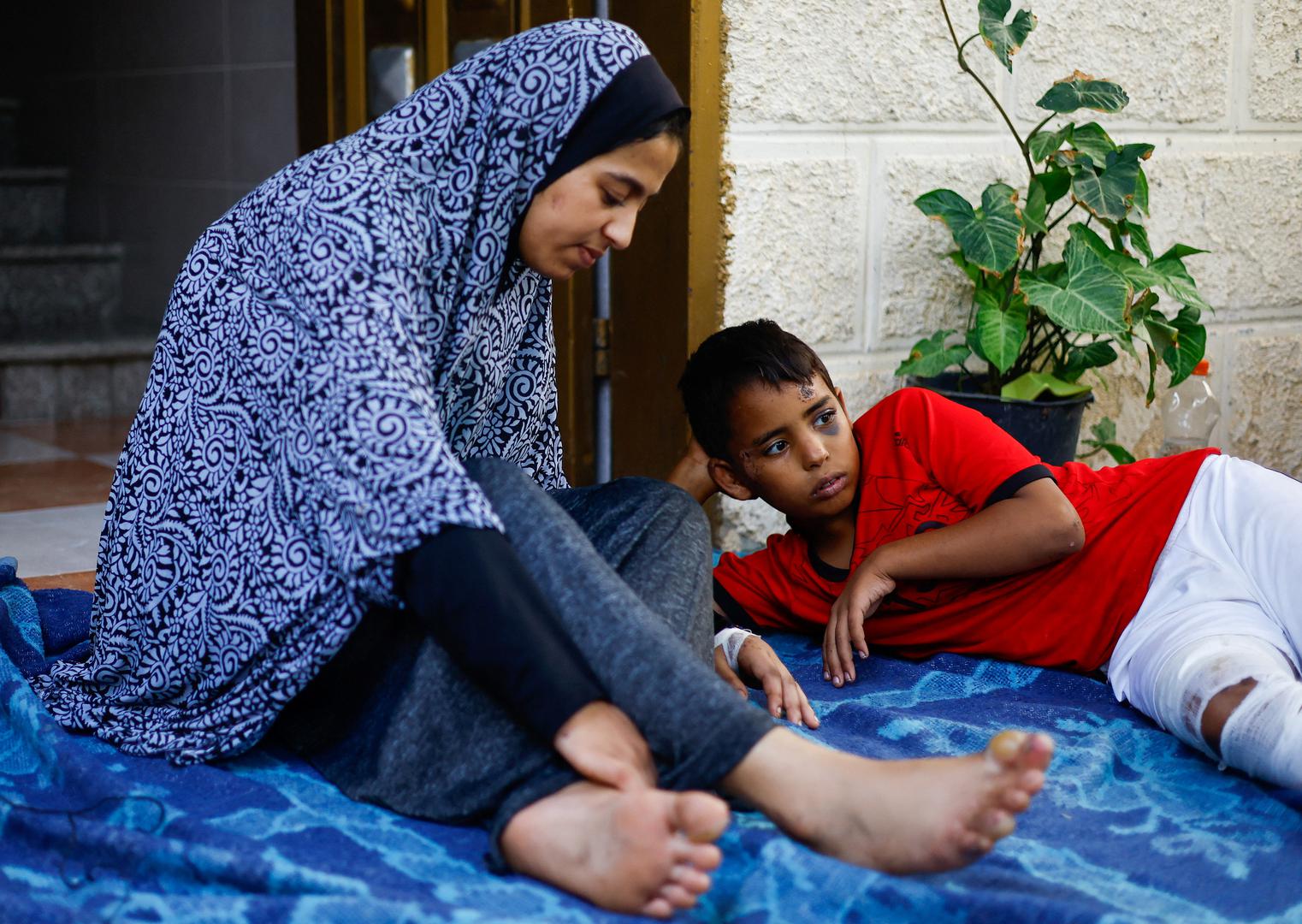 Palestinian teenager Dima Allamdani, who fled to southern Gaza Strip with her family to avoid the constant onslaught of Israeli airstrikes in Gaza City and settled in a shelter that was later hit by Israeli jets which killed 13 of her relatives, including her parents, 7 siblings and 4 members of her uncle's family, sits next to a boy, in Khan Younis in the southern Gaza Strip, October 22, 2023. REUTERS/Mohammed Salem Photo: MOHAMMED SALEM/REUTERS