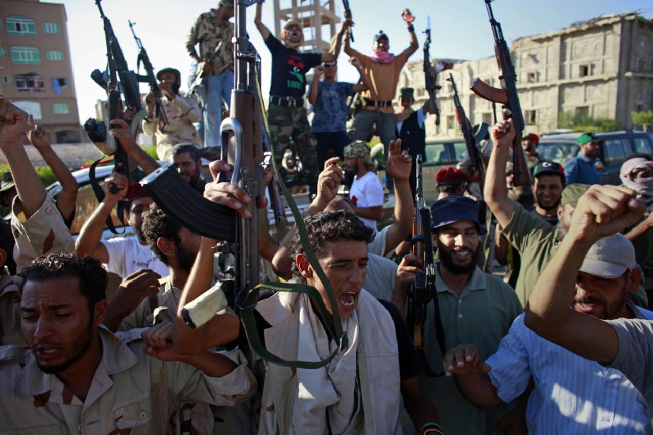 'Rebel fighters celebrate after taking control of the coastal town of Sabratha, 65 km (40 miles) west of Tripoli, August 18, 2011. Libyan rebels seized an oil refinery in the city of Zawiyah and took 