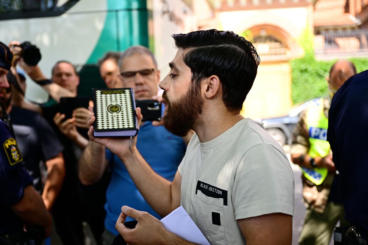 A person holds a Koran in his hand during a demonstration, in Stockholm