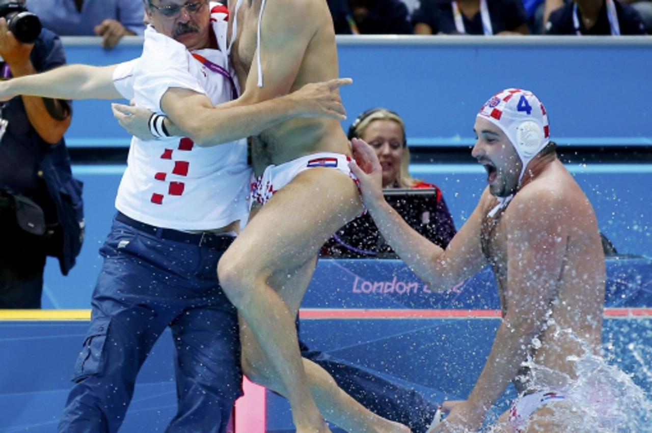 'Croatia\'s bench and Ratko Rudic (C) and Ivan Buljubasic (C) jump in to the water as they defeated italy during their men\'s gold medal water polo match during the London 2012 Olympic Games August 12
