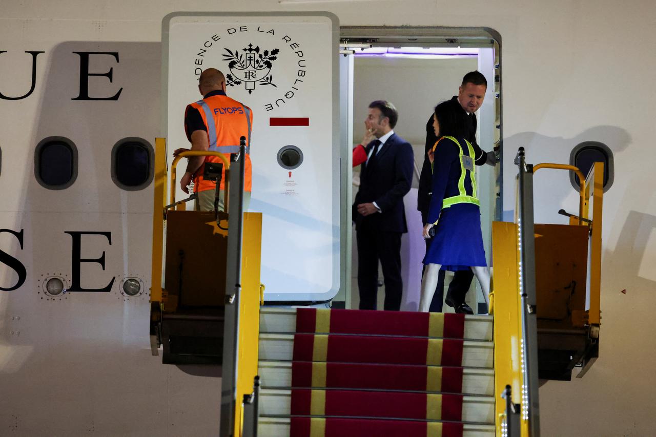 Macron's face appears to be shoved by wife in Vietnam