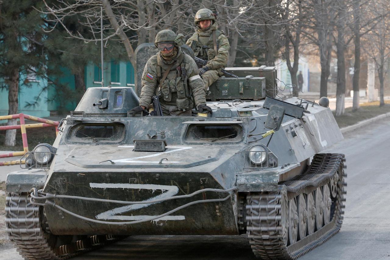 Service members of pro-Russian troops are seen atop of an armoured vehicle in Dokuchaievsk