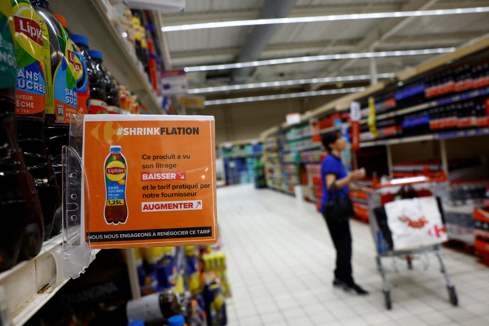 A sign reading "Shrinkflation, This product has seen its liter decrease and the price charged by our supplier increase" as a customer shops at a Carrefour supermarket in Montesson near Paris, France, September 13, 2023. REUTERS/Sarah Meyssonnier Photo: Sarah Meyssonnier/REUTERS