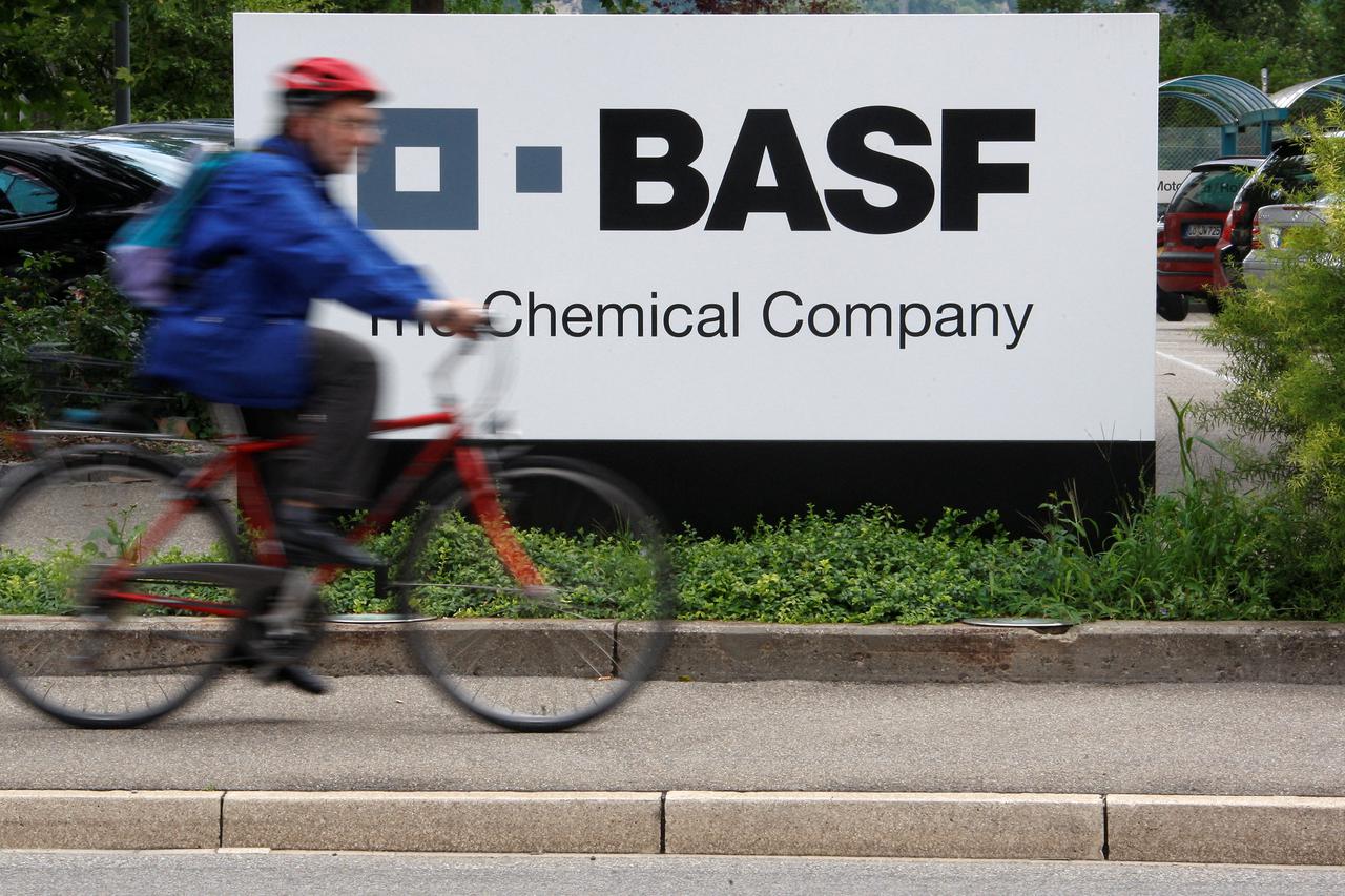 FILE PHOTO: A cyclist rides his bike bast the entrance of the BASF plant in Schweizerhalle