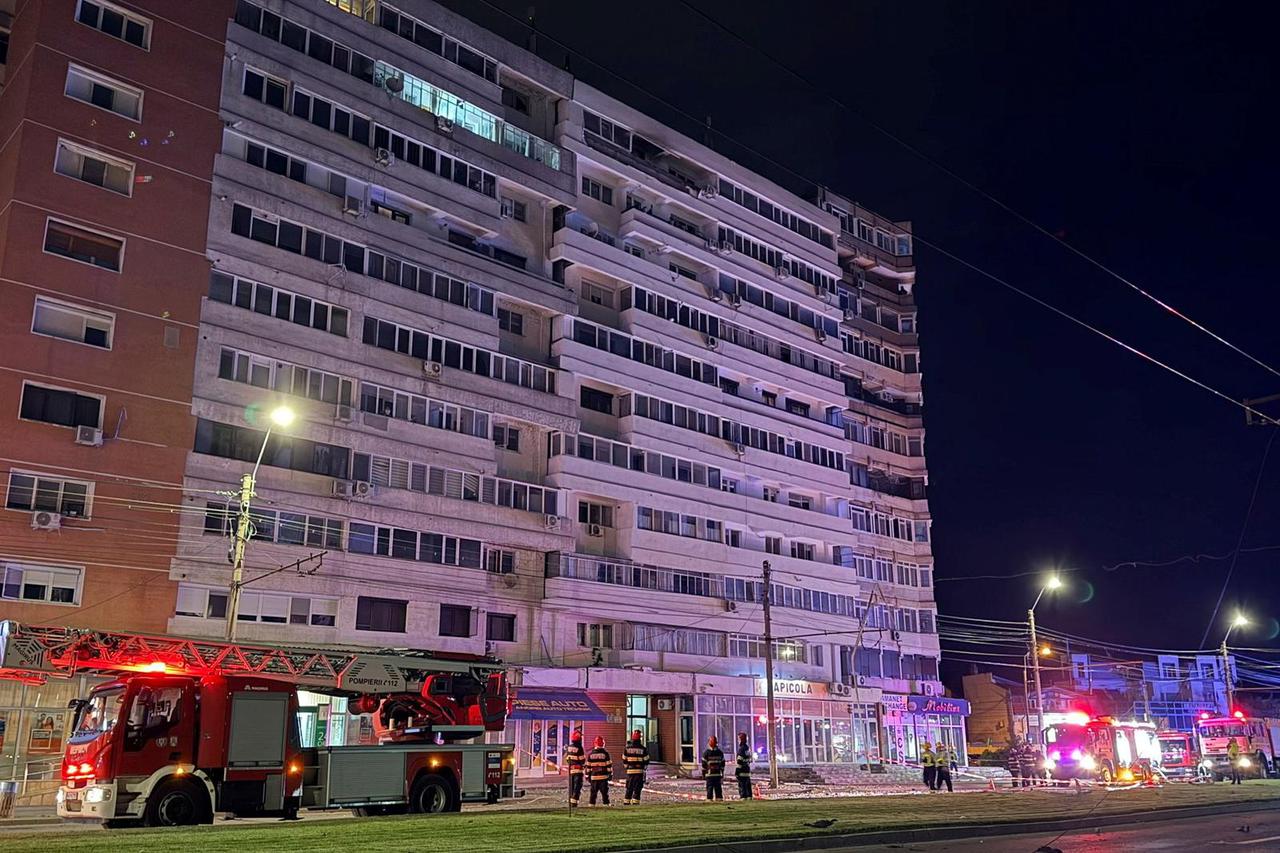 Firefighters and law enforcement work on the site of an explosion at a residential block of flats following a drone hit close to the border with Ukraine