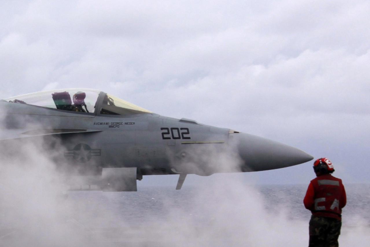 'A U.S. Navy F-18 strike fighter aircraft prepares to take off from the deck of the USS George Washington aircraft carrier off the coast of Brisbane July 23, 2013. The U.S. Navy on Tuesday offered Aus