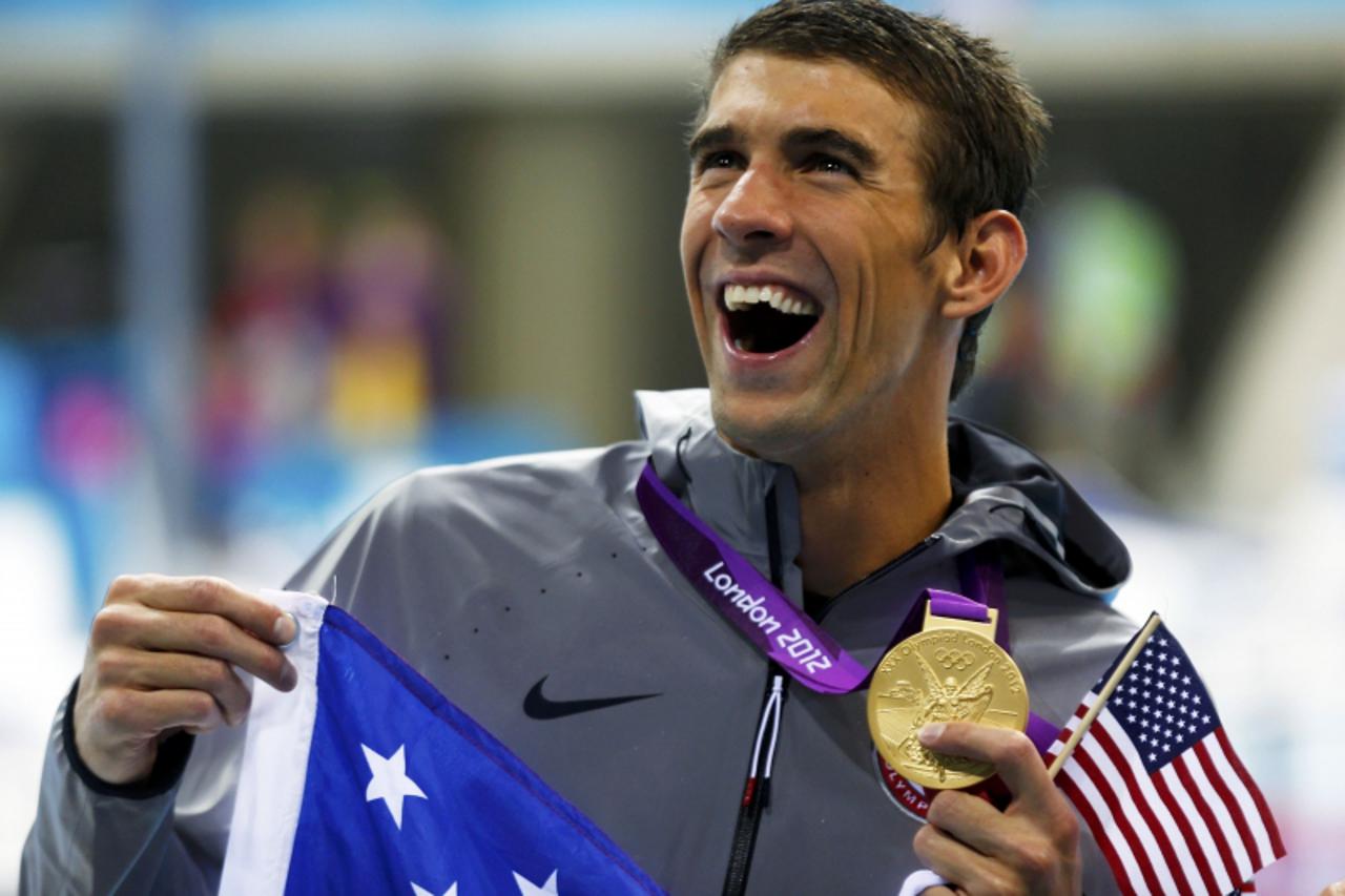 'Michael Phelps of the U.S. holds his 19th Olympic medal presented to him in the men\'s 4x200m freestyle relay victory ceremony during the London 2012 Olympic Games at the Aquatics Centre July 31, 201