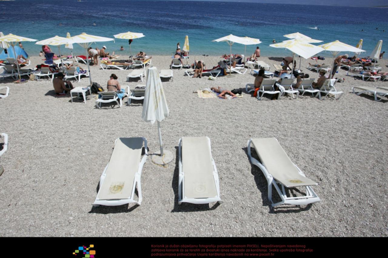 '14.06.2012., Bol - Turisti i domaci uzvali su u suncanju na plazi, ali zbog vjetra i hladnog mora nisu bili odlucni za kupanje.  Photo: Borna Filic/PIXSELL'