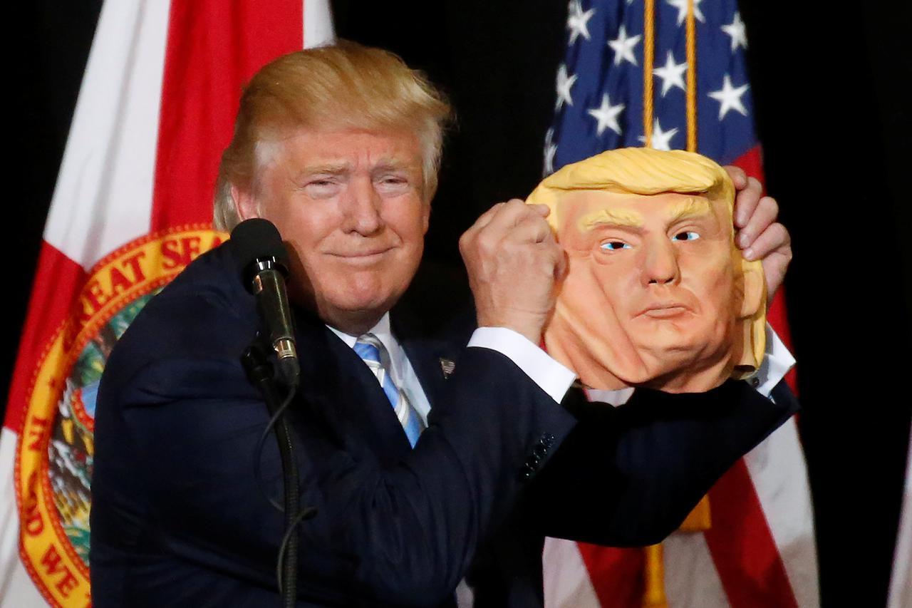 Republican presidential nominee Donald Trump holds up a mask of himself as he speaks during a campaign rally in Sarasota, Florida, U.S. November 7,  2016.   REUTERS/Carlo Allegri     TPX IMAGES OF THE DAY     