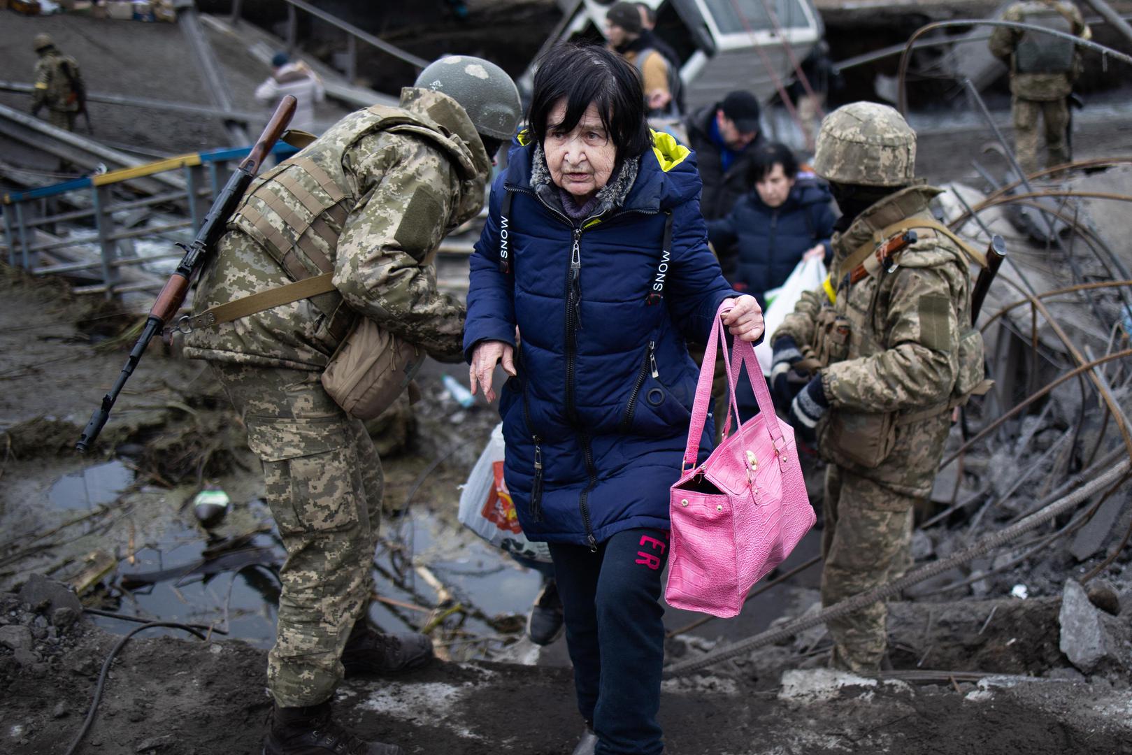 Soldiers help people cross a destroyed bridge as they evacuate the city of Irpin, northwest of Kyiv, during heavy shelling and bombing on March 5, 2022, 10 days after Russia launched a military invasion on Ukraine. Photo by Raphael Lafargue/ABACAPRESS.COM
