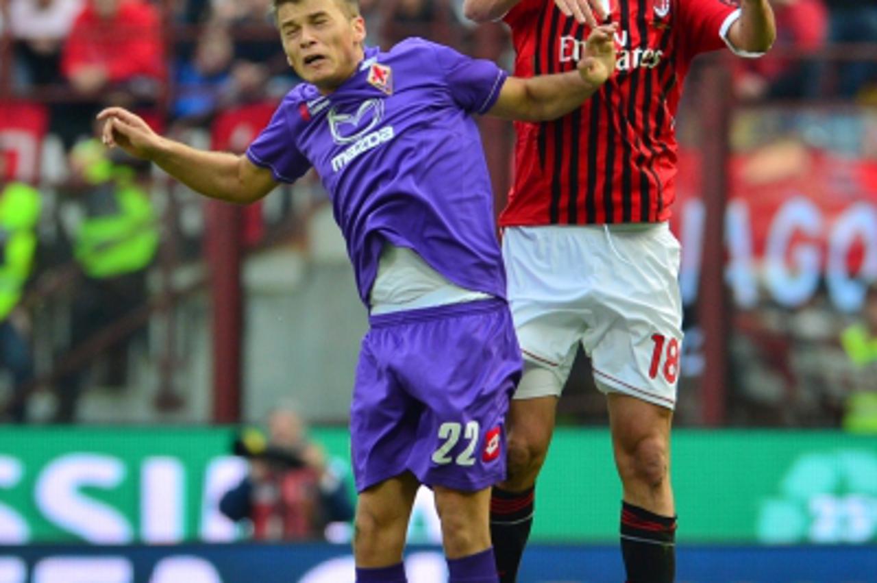 'Fiorentina\'s Serbian midfielder Adem Ljajic  (L) fights for the ball with AC Milan\'s midfielder Alberto Aquilani during the Italian Serie A football match between AC Milan and Fiorentina at San Sir