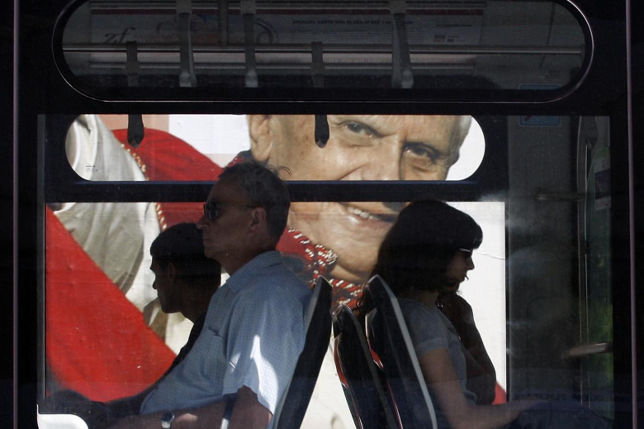 'A tram passes in front of a billboard featuring Pope Benedict XVI\'s in Zagreb on May 27, 2011. Pope Benedict will visit Zagreb on June 4-5.   REUTERS/Nikola Solic (CROATIA - Tags: POLITICS RELIGION)