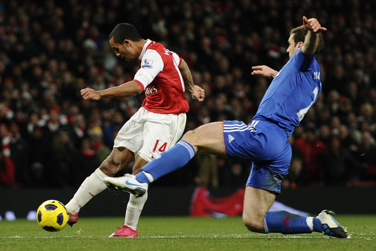 'Arsenal\'s Theo Walcott (L) scores against Chelsea during their English Premier League soccer match at the Emirates Stadium in London December 27, 2010.    REUTERS/Dylan Martinez (BRITAIN - Tags: SPO