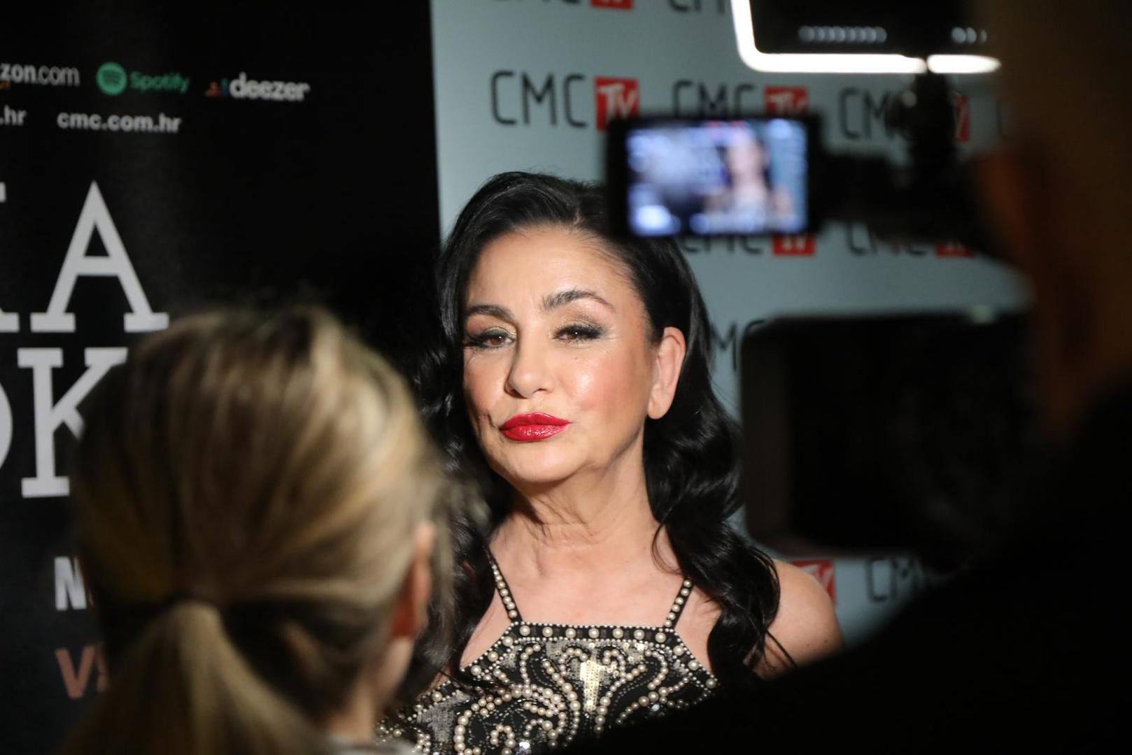 Alka je pak za koncert odabrala kratku haljinu neobičnog uzorka. Svoju dugu crnu kosu je blago uvila, a na licu je posebno istaknula usne i to crvenim ružem. 

